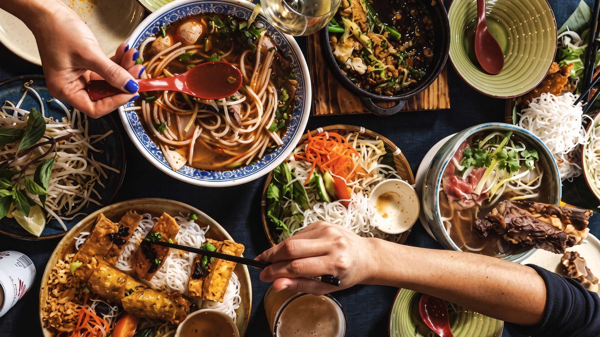 A shared table of phở, vermicelli and rice dishes